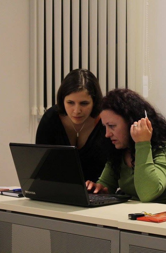 Barbara Turk Rupnik pomaga udeleženki pri delu na prenosniku
